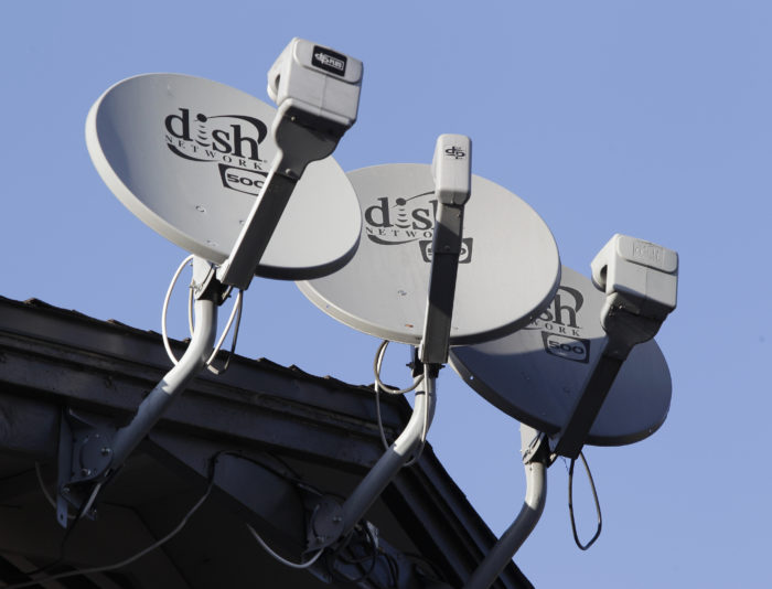 Photo of 3 TV satellite dishes on a rooftop.